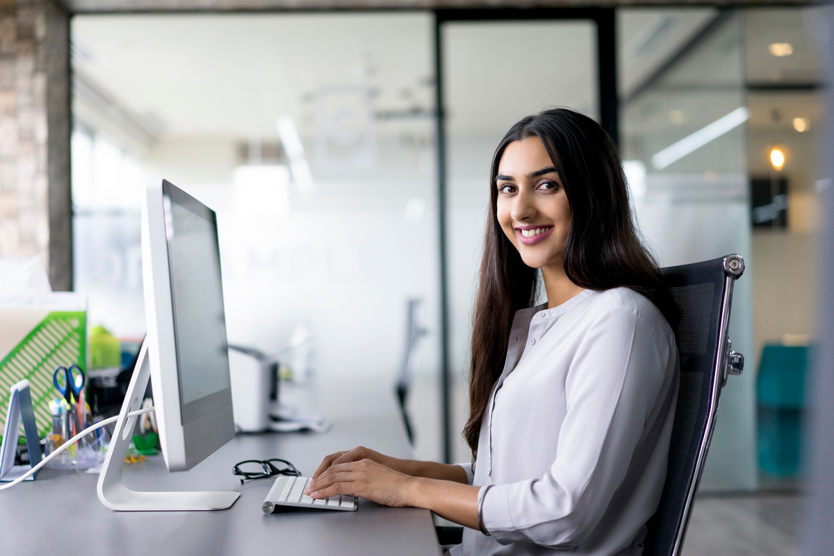 Portrait of Happy Female Employee at Computer